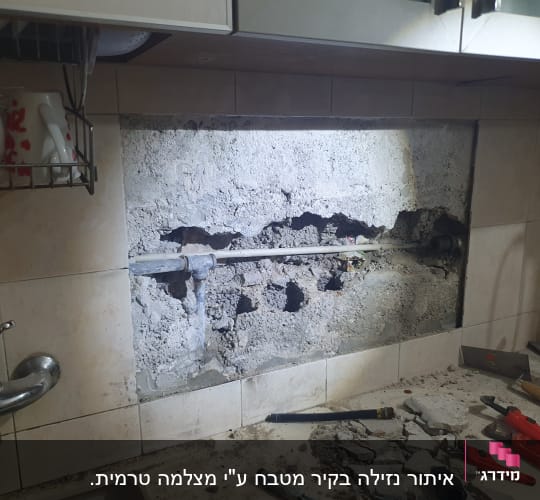 קיר פתוח עם צינור חשוף וכלי עבודה